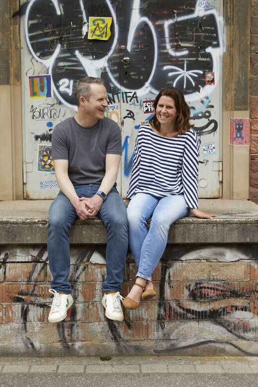 Sebastian und Jessie Wölke sitzen auf einer Mauer.