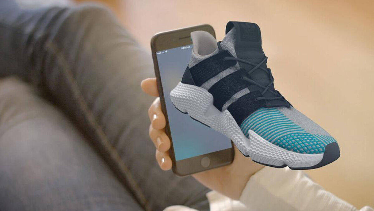 Beispiel für Spatial Commerce mit einem im Raum schwebenden Sneaker über einem Smartphone-Display.