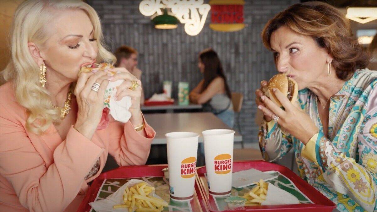 Désirée Nick und Claudia Obert essen einen Burger. 