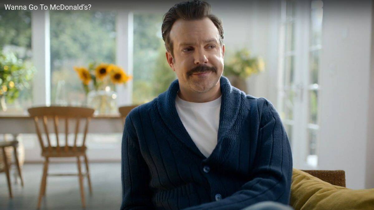 Jason Sudeikis sitzt in Ted-Lasso-Manier im Sessel und ist sauer. 