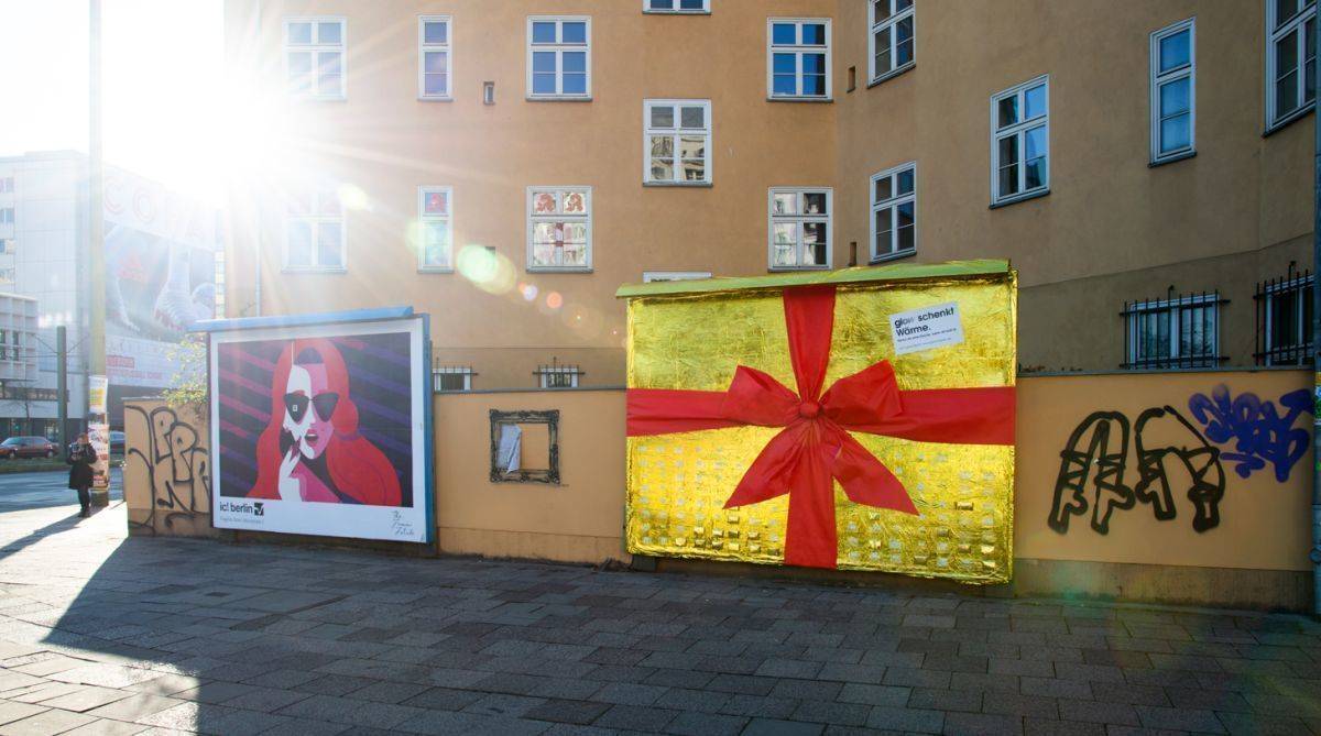 Die Werbeagentur Glow spendet Wärmedecken auf einer Plakatwand in Berlin Mitte.