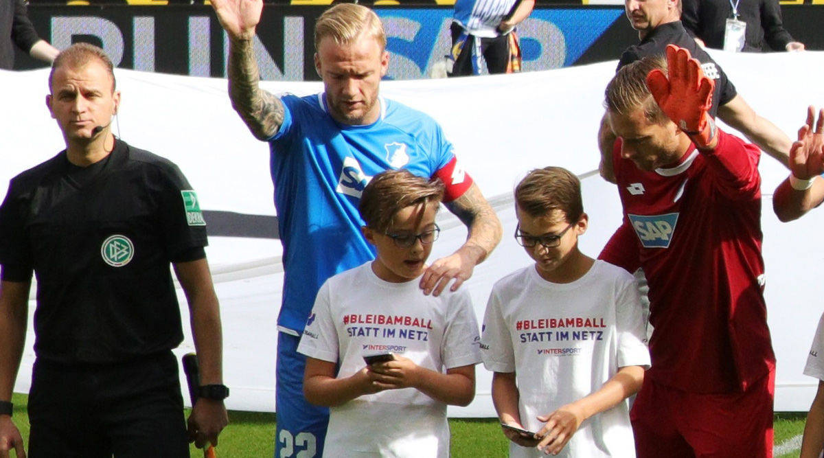 Die Kinder interessieren sich nur für ihr Smartphone - und nicht für ihre Fußballstars.