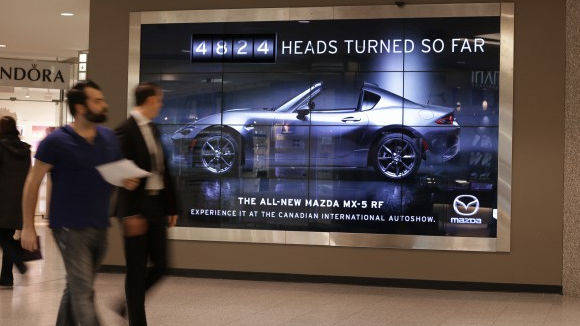 Das Plakat misst, ob der Mazda auch wirklich ein Hugucker ist.