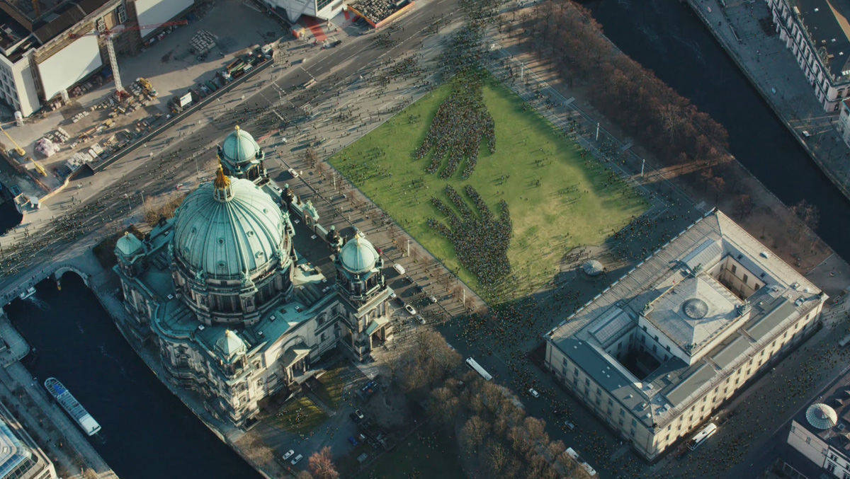 Im Spot strömen Mitarbeiter der beteiligten Unternehmen und Geflüchtete in Berlin zusammen. 