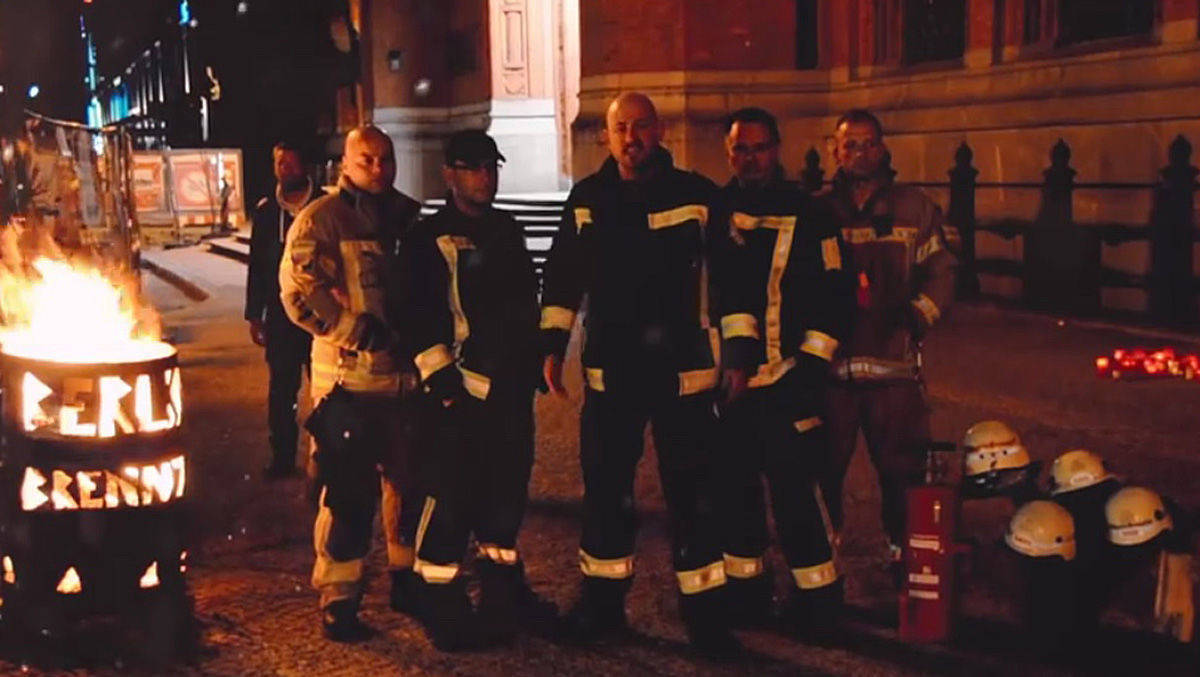 Feuerwehrmann Christian Köller (M.) und seine Berliner Kollegen protestierten mit Tonne vor dem Rathaus - und formulieren ihre Probleme als Rap.