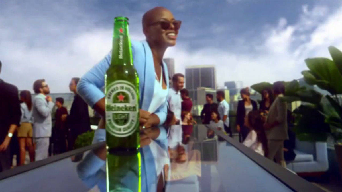 Das Heineken-Light-Bier passiert drei farbige Party-Gäste, bevor es bei einer hellhäutigen Frau ankommt. 