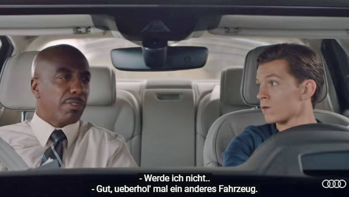 Tom Holland (r.), der junge Spider-Man im aktuellen Kinohit, legt seine Fahrprüfung im A8 von Audi ab.