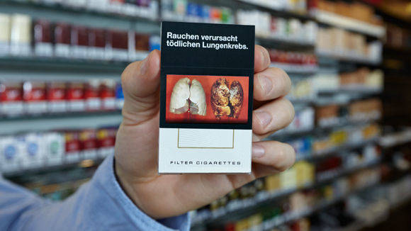 Mit Plastikkarten decken immer mehr Händler diese Schockbilder auf Zigarettenpackungen ab.
