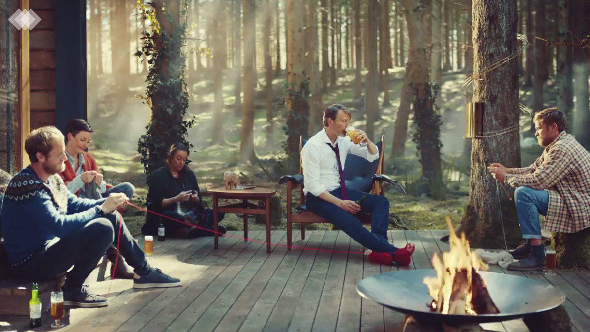 Mads Mikkelsen mit Carlsberg-Pils am Lagerfeuer.