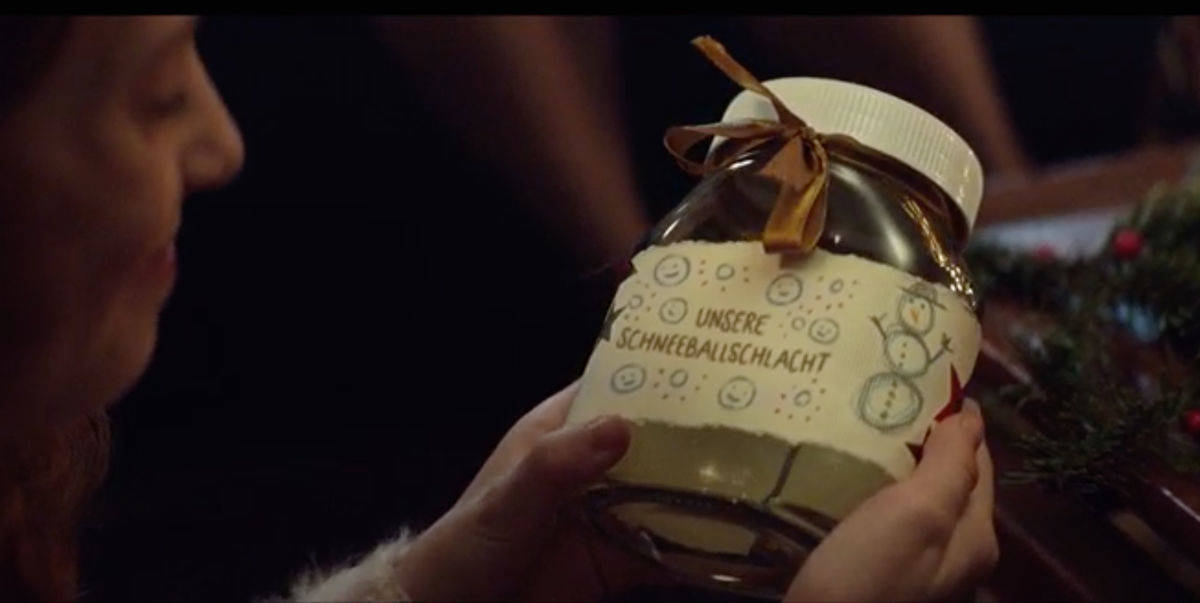 Der Junge schenkt der Schwester die Erinnerung an die gemeinsame Schneeballschlacht im Nutella-Glas.