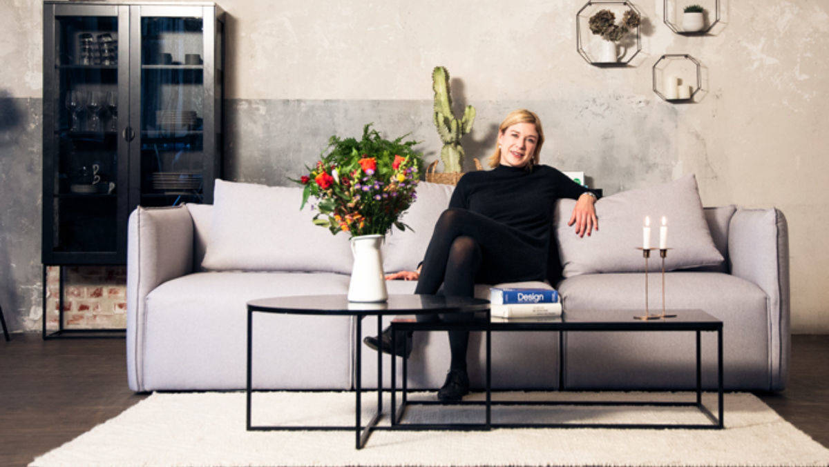 Jenny Feldmann von Elbgestoeber sitzt auf ihrer neuesten Kreation: dem Otto-Sofa „Elbdock“.