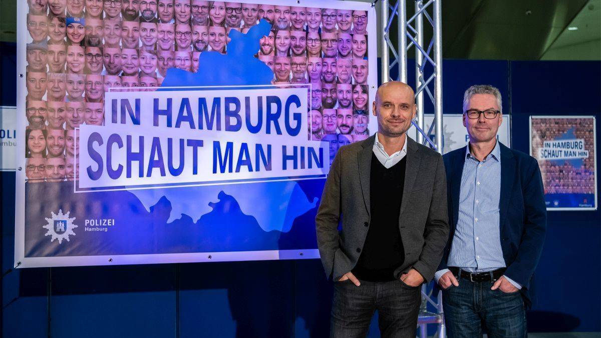 Andreas Ottensmeier (l.) und Carl-Christian Berge von Battery spielen mit dem bekannten Spruch "In Hamburg sagt man Tschüss".