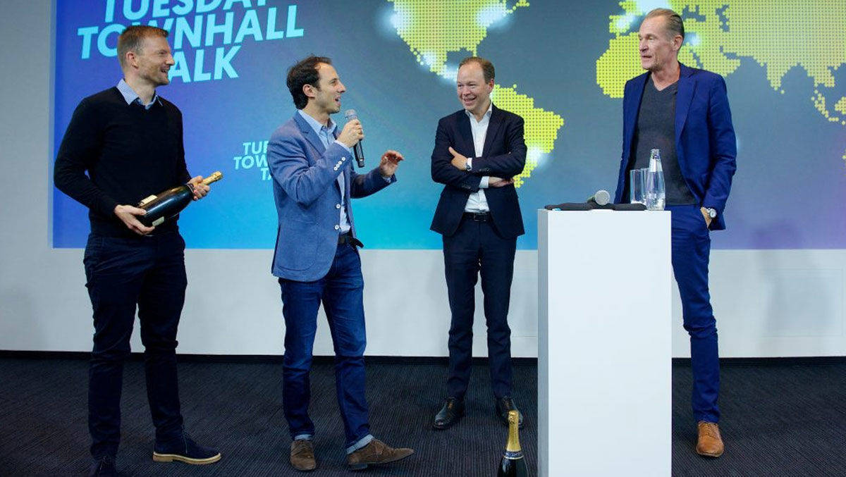 Vorstandschef Mathias Döpfner (r.) und Finanzvorstand Julian Deutz (2. v.r.)  gratulieren Stefan Betzold und Tobias Henning (l.). Vorn und links: Champagner.