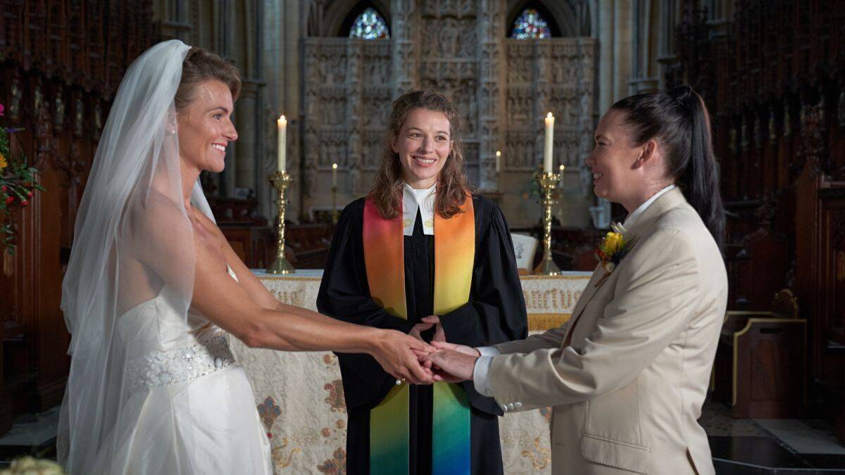 Entgegen ihren Anweisungen traut Rebecca (Antonia Bill, M.) in der Anglikanischen Gemeinde ein gleichgeschlechtliches Paar (Emma Skinner, l., und Rachel Leigh, r.).