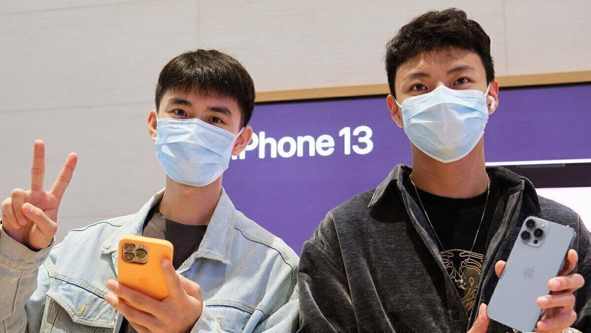 Zwei Käufer, die sich über ihr neues iPhone 13 von Apple freuen.